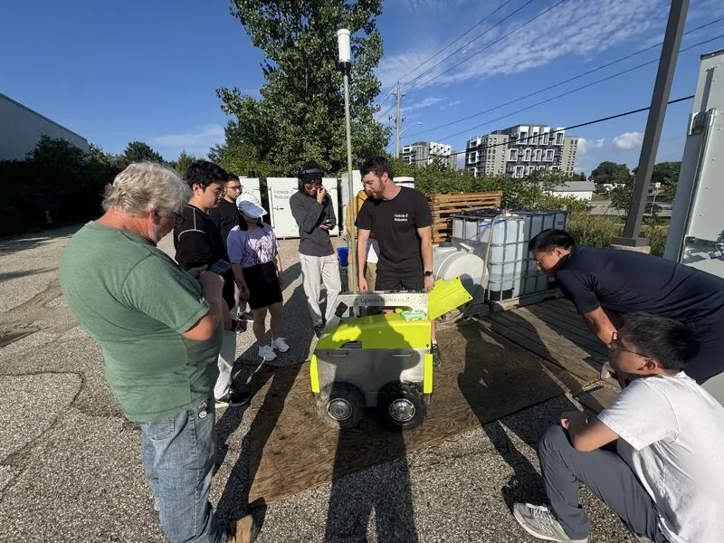 SPAIS members learning about an Upside Robotics agricultural robot during a company visit.